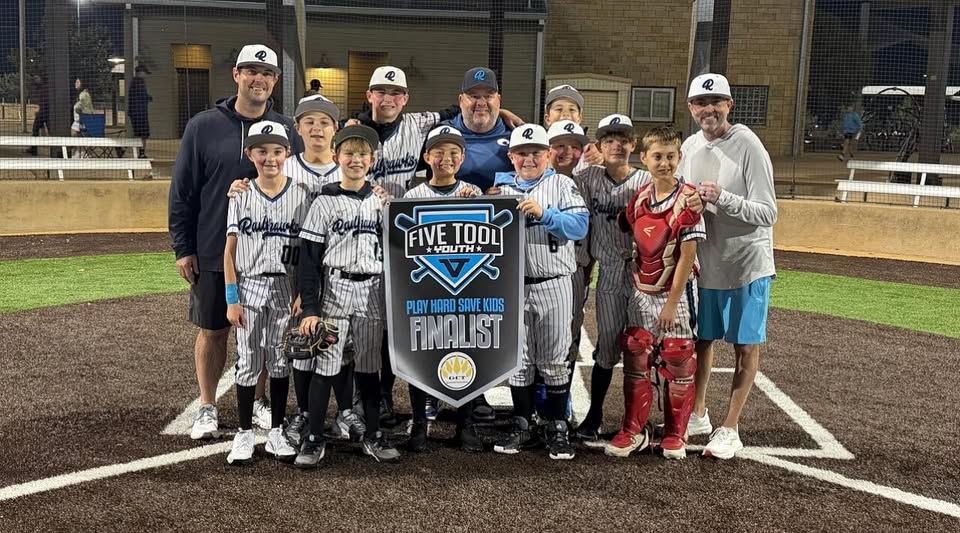 Texas Railhawks 12U team holding Five Tool Youth Finalist banner at home plate under lights