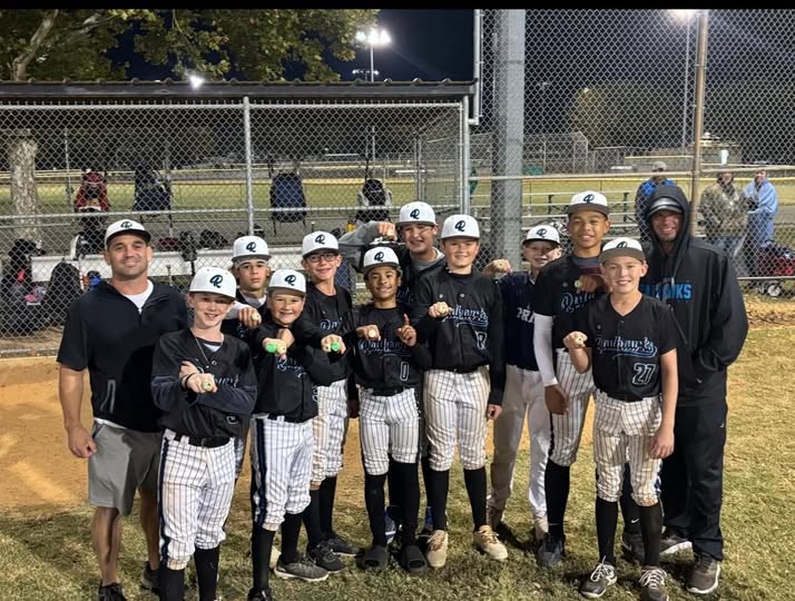 Texas Railhawks 13U travel baseball team posing under field lights at night with coaches