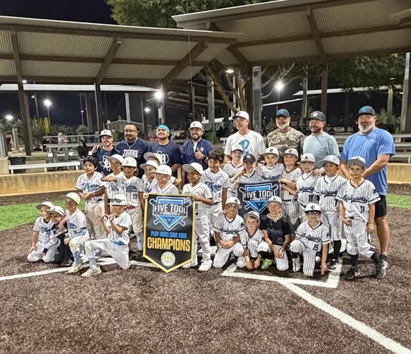 Texas Railhawks 8U team celebrating Five Tool Youth Champions title at night with coaches in Argyle TX
